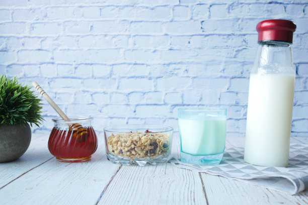 早餐麦片在碗里，牛奶和蜂蜜在木桌的背景上图片下载