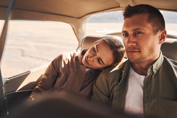 美丽的年轻夫妇在车里拥抱在一起图片下载