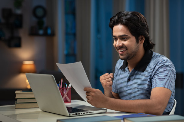 一个年轻男子大学生使用笔记本电脑在家学习的肖像:-库存照片图片下载