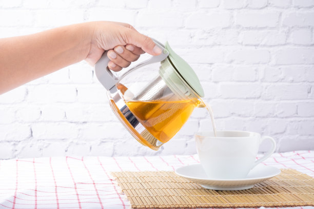 女人用手把热茶倒进杯子里图片下载