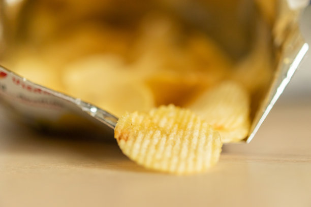 脆薯片装在零食袋里放在木桌上图片下载