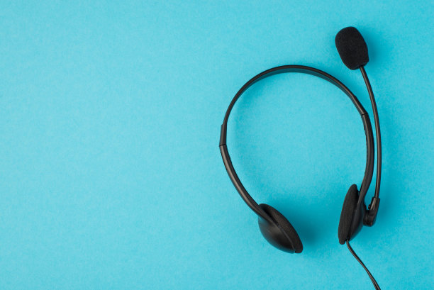 俯视图照片的黑色耳机与麦克风在孤立的蜡笔蓝色背景与copyspace图片下载