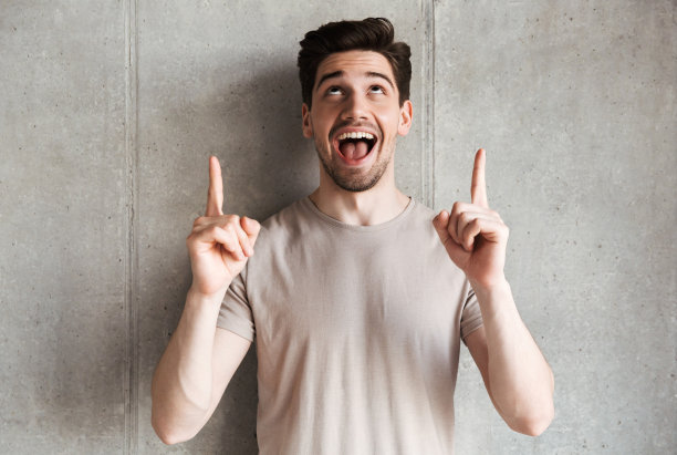 兴奋的微笑的年轻人指着文案。图片下载