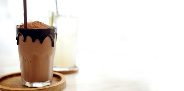 冷巧克力饮料与融化滴边装饰在舒适的白色现代咖啡馆风格与复制空间图片下载