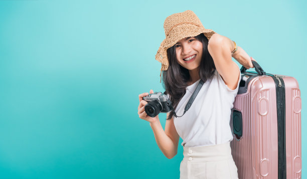女人穿着白色t恤，拿着旅行袋和照片无反光镜相机图片下载