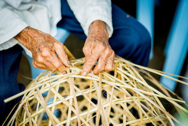 一位老人正在用手编一个竹篮。这是老年人可以做的工作。图片下载