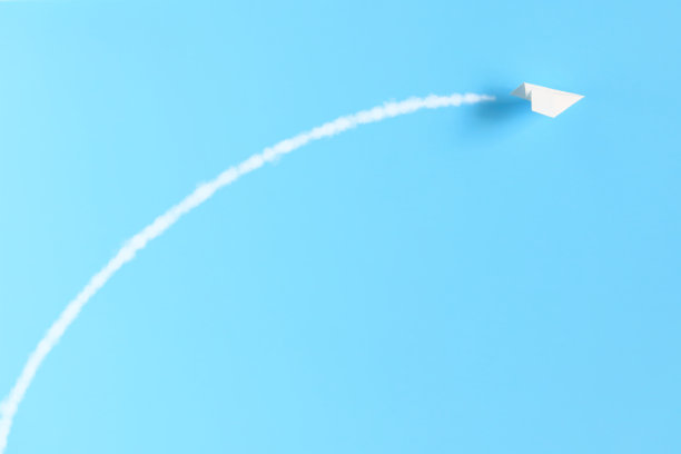 有尾迹的纸飞机。图片下载