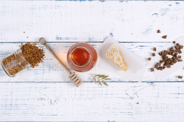 蜂蜜的背景。养蜂产品蜂蜜，花粉，蜂胶，蜂巢放在木桌上。复制你的文本空间。图片下载