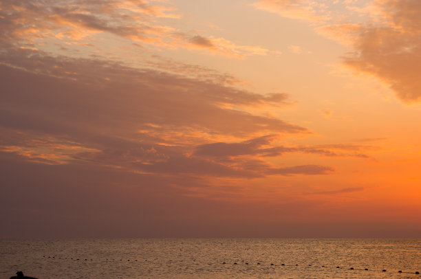 卵石滩上惊人的海上日落，太阳，海浪，云彩图片下载