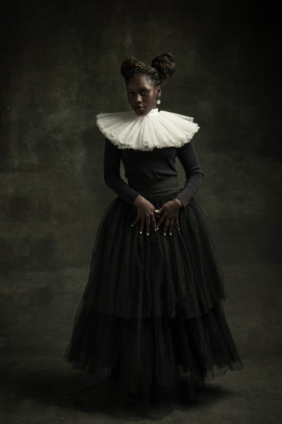 中世纪非洲年轻女子黑色复古连衣裙与大白领摆姿势孤立在深绿色的背景。比较时代、现代性和文艺复兴的概念。图片下载