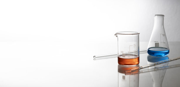 两个实验室玻璃瓶和化学液体，移液器放在玻璃桌上。空的空间图片下载