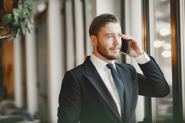 一个男人站在办公室里打电话图片下载