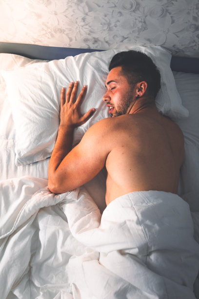 年轻性感的白人男人在床上从天顶的角度图片下载