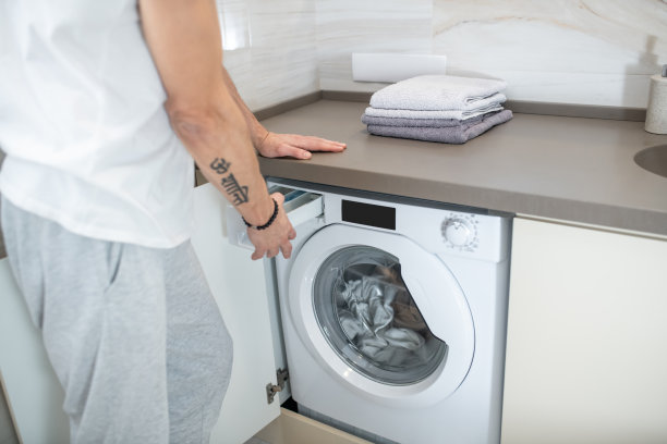 男人的手打开洗衣机的特写照片图片下载