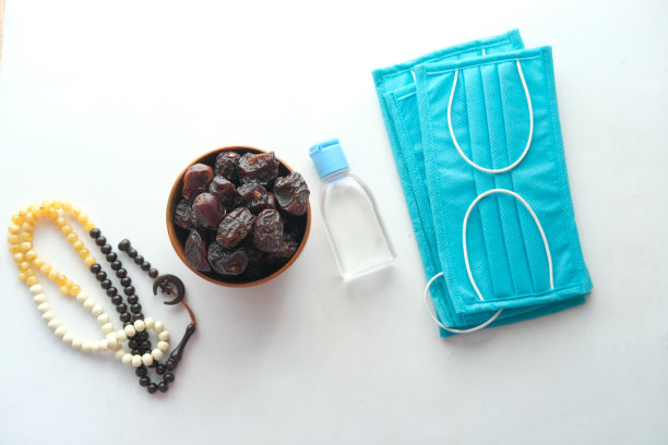 碗里放着新鲜的枣子、念珠、洗手液和口罩图片下载