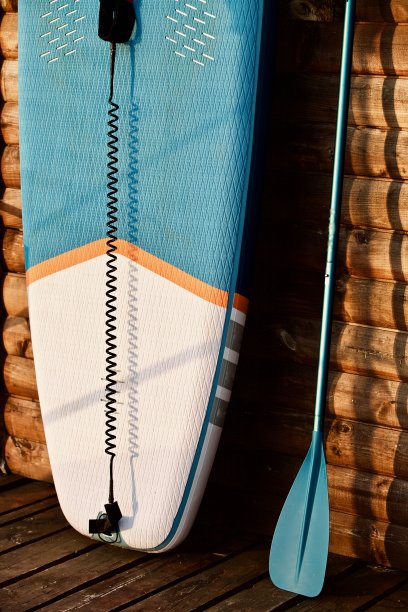 桨板和冲浪板与桨在棕色的木墙背景接近图片下载