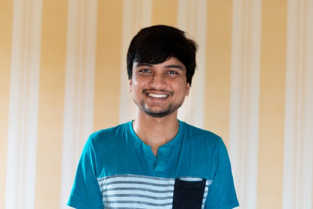 正面25岁的印度男性微笑着看着镜头。成功的青少年盯着相机，快乐的学生或实习生新员工的肖像图片下载