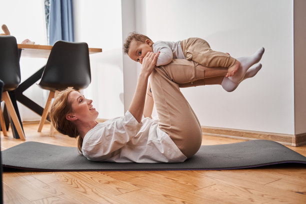 一位穿着家服的妇女躺在后面，儿子躺在她的膝盖上图片下载