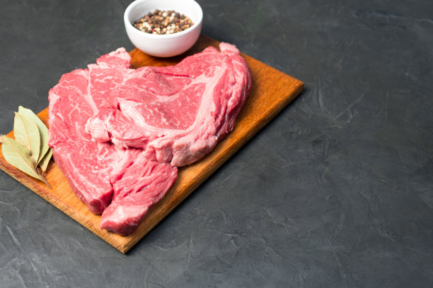 生大理石牛排。特写照片在黑暗的背景。图片下载