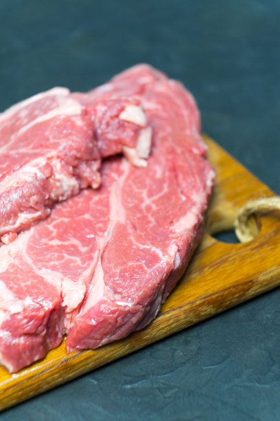 生大理石牛排。特写照片在黑暗的背景。图片下载