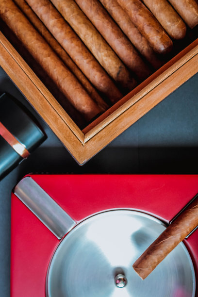 打开雪茄盒、烟灰缸和雪茄炬。烟具配件。豪华生活方式平躺俯视图，垂直图片下载