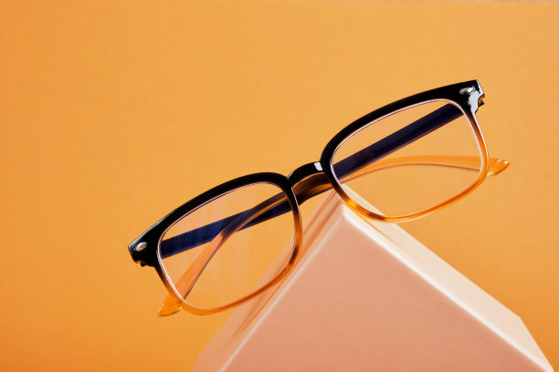 眼镜上的米色礼盒，棕色背景，复印空间，折扣和促销在光学商店图片下载