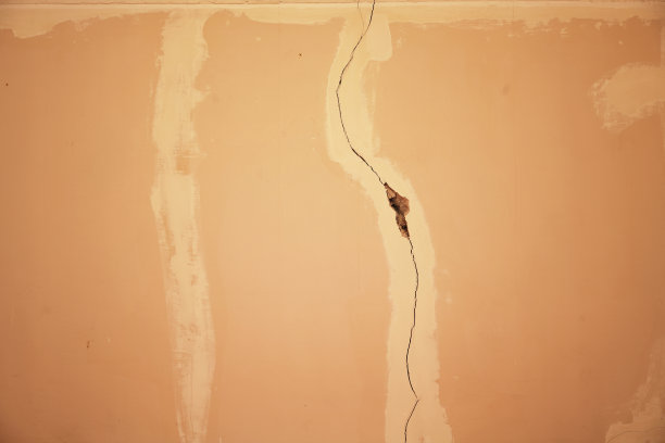 老米色混凝土建筑墙体有垂直裂缝。图片下载