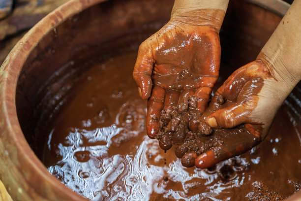 泰国棉花工匠。树皮和火山泥在手边。罐子的树皮和火山泥是用来染色棉和丝绸的天然颜色是泰国Buriram的智慧。图片下载