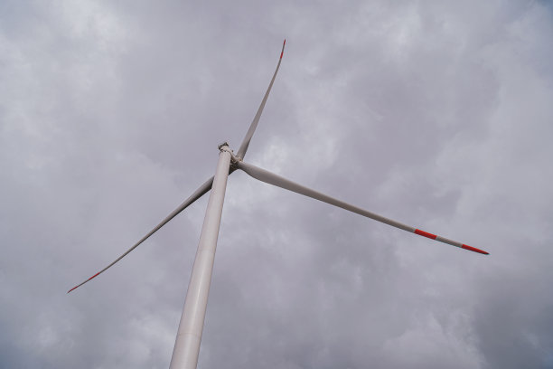 阴天下的草原上的风力发电机图片下载