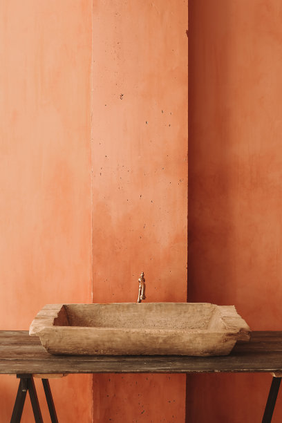 简约的室内风格。木质架子上的老式水槽，橙色的垃圾墙背景。图片下载