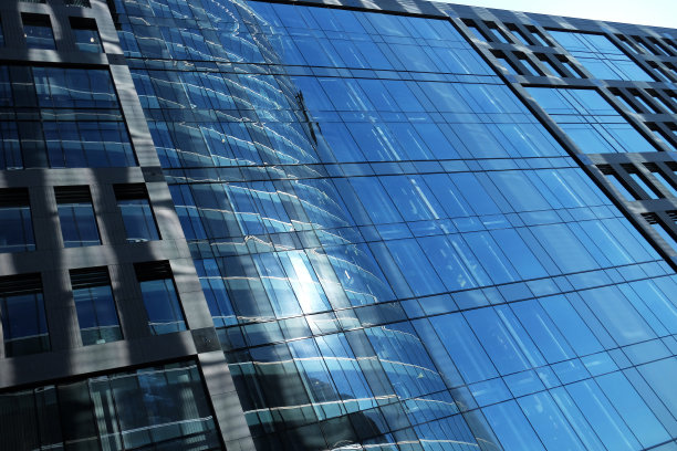 办公楼外夏日阳光明媚。湛蓝的天空映在玻璃窗上图片下载