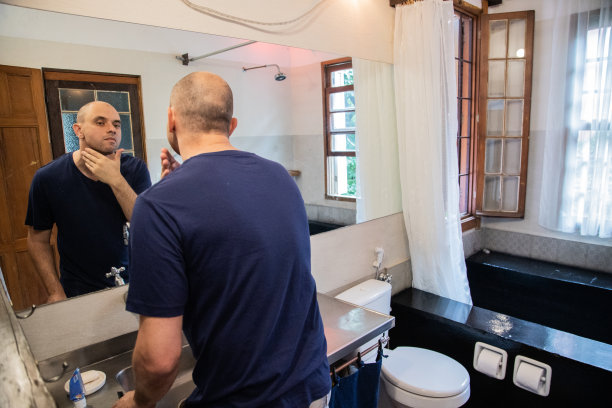 成熟的男人在家看镜子分析脸图片下载