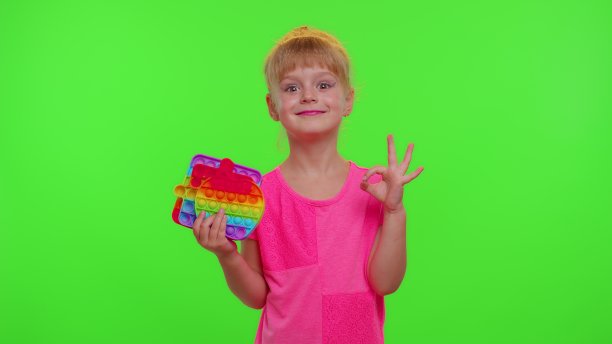 小女孩手里拿着许多五颜六色的软软的硅胶泡泡，pop it流行感官玩具，竖起大拇指图片下载