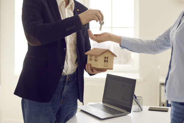 房地产经纪人拿着小房子模型给客户钥匙的剪发照片图片下载