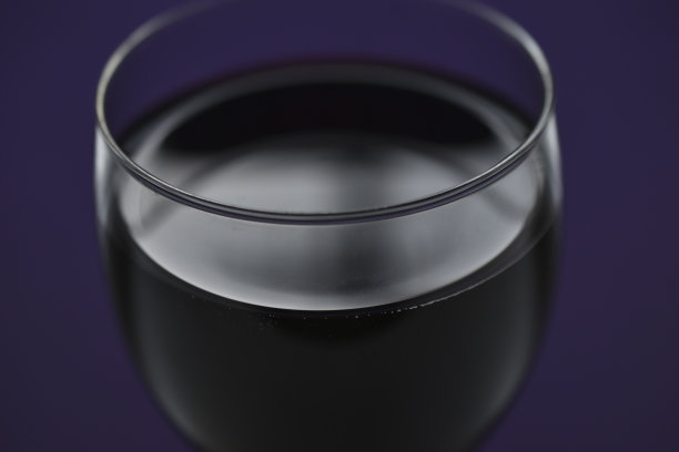 紫色背景上的一大杯红酒图片下载