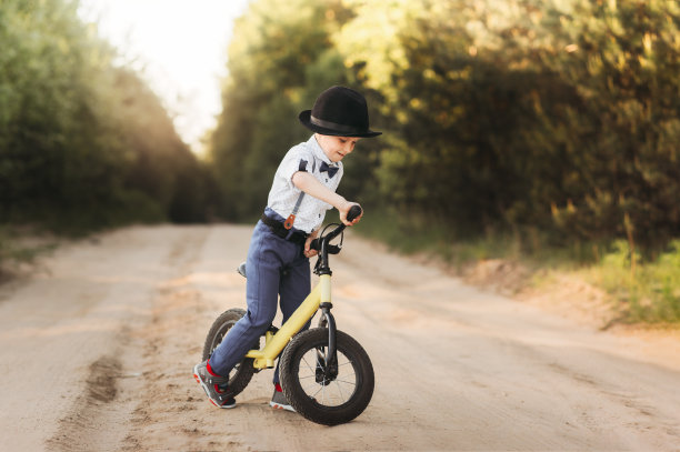 小男孩在夏日的大自然中骑着平衡自行车。不用踏板骑自行车图片下载
