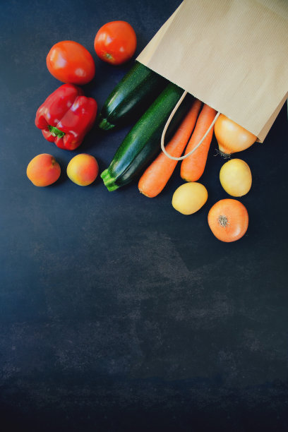 购物或配送健康食品理念。食品超市和清洁素食的概念。新鲜蔬菜和水果:胡萝卜，土豆，西葫芦，番茄纸袋黑色背景图片下载