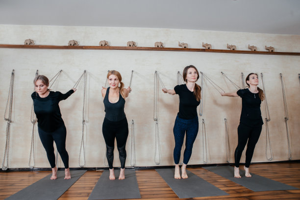 一群练习健美操的女瑜伽修行者在瑜伽房里用绳子挂在墙上图片下载
