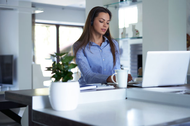 自由接线员与耳机和咨询客户从家庭办公室。图片下载