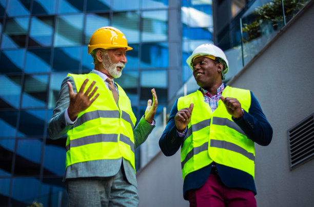 成熟的工程师在施工现场与建筑师同事讨论建筑结构。图片下载