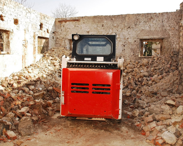 在废弃的建筑撬转向装载机图片下载