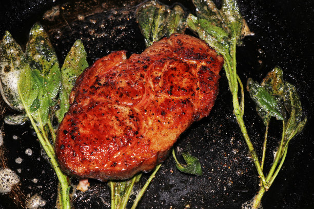 用鼠尾草腌制的猪肋眼肉在热烤盘上烹饪图片下载