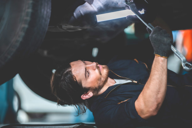 汽车修理工车库汽车服务，修理和保养汽车，技术人员车间的汽车发动机和工作与电机工具图片下载