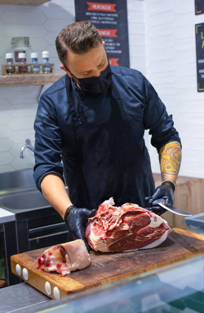 屠夫在他的店里切一块新鲜的农场肉图片下载
