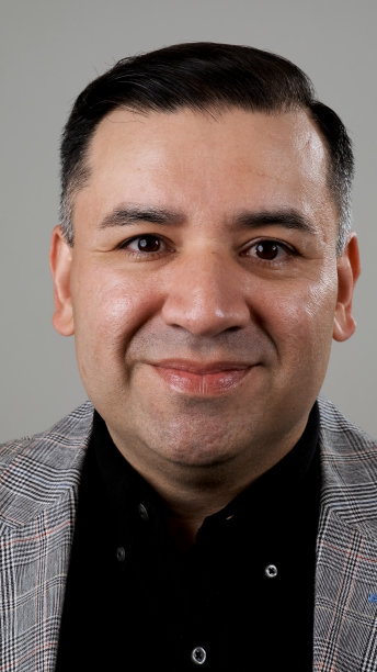 微笑的成熟男子看着灰色背景的相机图片下载