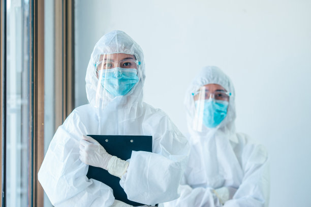 疫情危机期间，医务人员集体讨论工作。2名身穿个人防护服或个人防护装备的亚洲医生隔离新冠病毒(Covid-19)图片下载