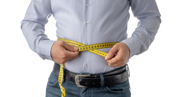 大肚子男人用卷尺量腰围图片下载