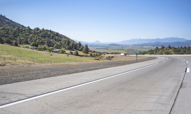勃艮第经典大钻机半挂车拖拉机与半挂车爬坡上转弯宽公路之间的丘陵图片下载