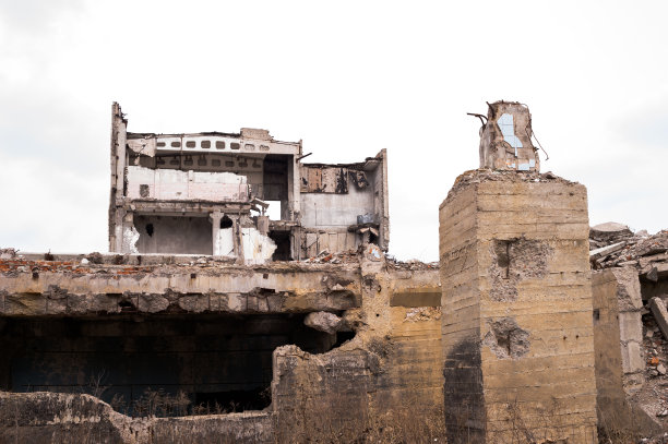 前景是一座废墟建筑的遗迹，上面有很大的地基桩。背景图片下载