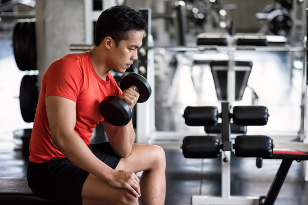 强壮的男子二头肌哑铃在健身房锻炼图片下载
